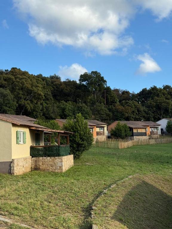 a house in a field with trees in the background at Villa T3 avec piscine in Sollacaro