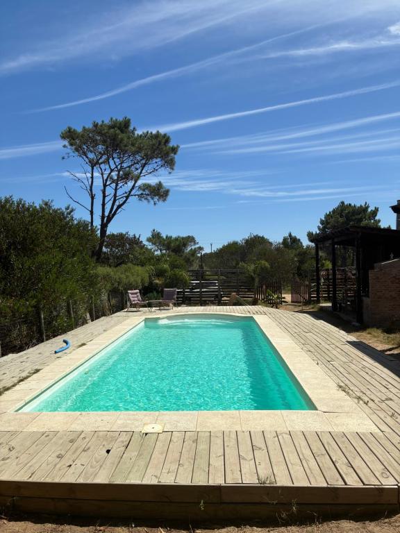 een zwembad met een houten terras en een blauwe bij Cielo abierto in Maldonado