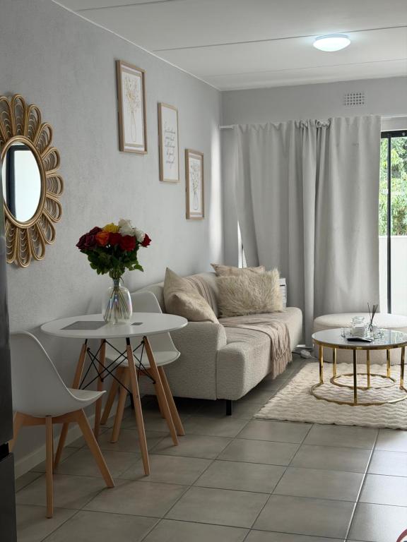 un soggiorno con un divano e un tavolo di Elevare suites a Nelspruit