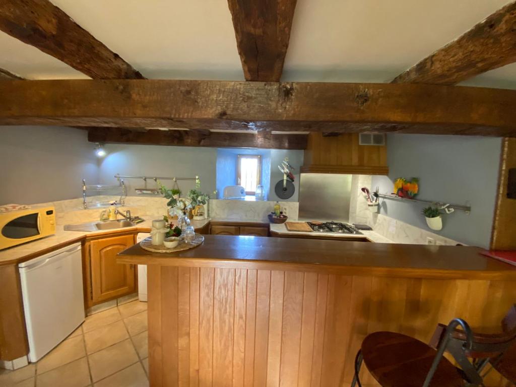 a kitchen with wooden cabinets and a counter top at La petite Chalvignacoise in Chalvignac