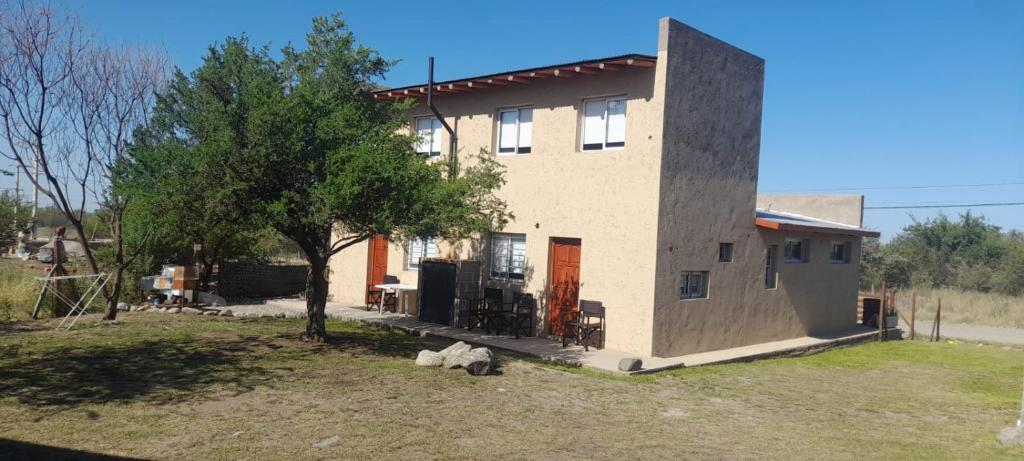 een huis met een boom ervoor bij cabañas sunrise in Merlo