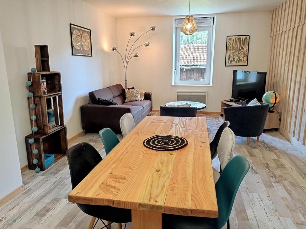 a living room with a wooden table and chairs at La Filature in Rochesson