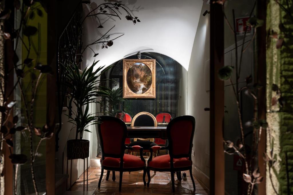 ein Esszimmer mit roten Stühlen und einem Tisch in der Unterkunft Locanda Sibilla Luxury Suites in Tivoli