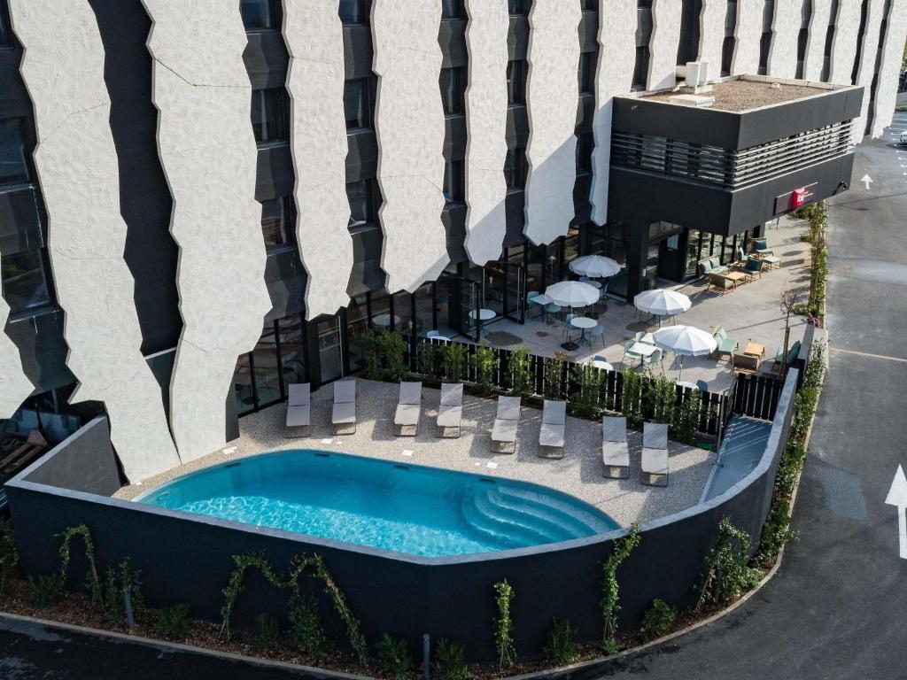 een bovenaanzicht van een zwembad voor een gebouw bij Ibis Lunel Petite Camargue in Lunel