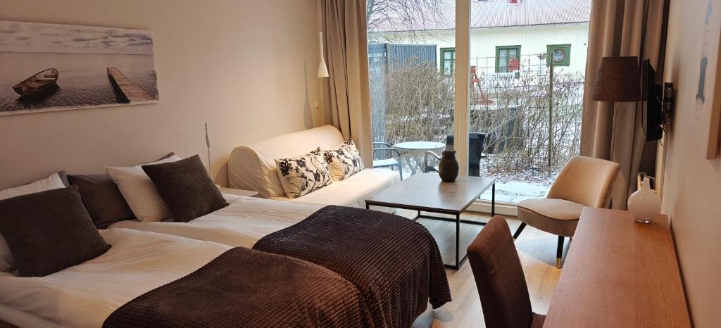 a living room with a bed and a couch and a table at Nösundsgården Hotell & Vandrarhem in Nösund
