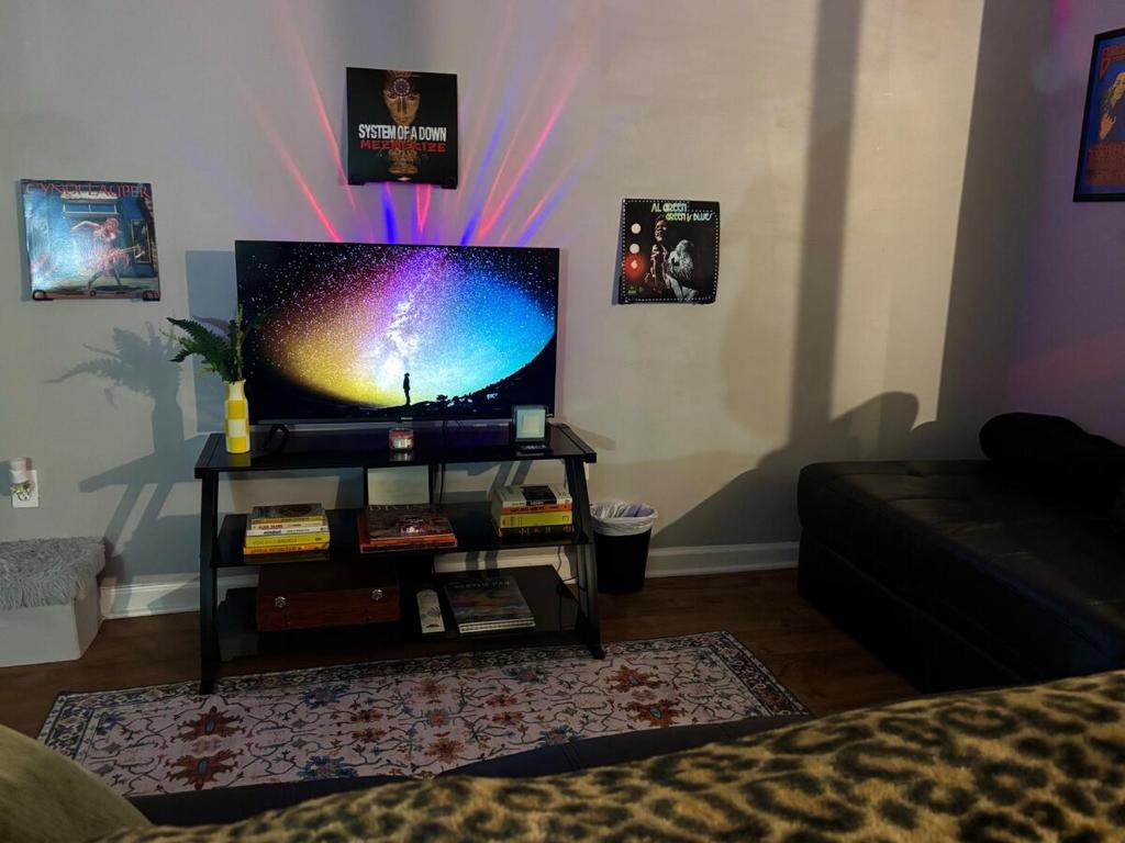 a living room with a flat screen tv on a table at Boston Edison Cozy Gallery Studio in Detroit