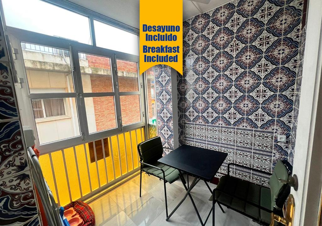 una stanza con tavolo e sedie accanto a un muro di Apartalux Isla Cristina a Isla Cristina