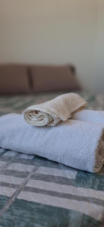 a rolled up towel sitting on top of a bed at Apartamento em Imbituba in Imbituba