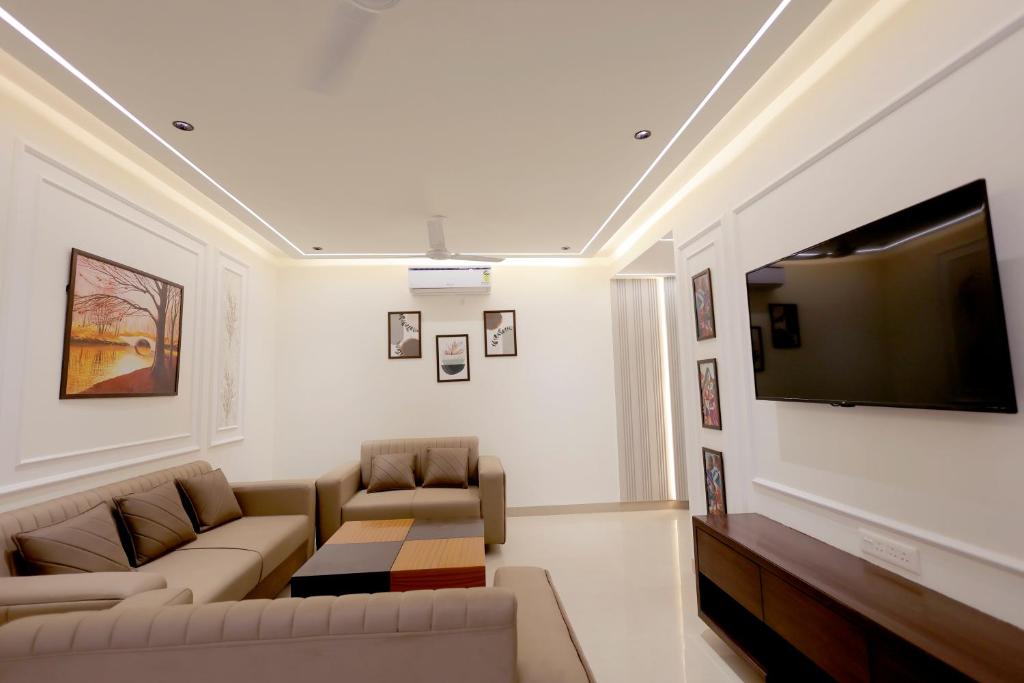 a living room with a couch and a flat screen tv at Supremo Home Stays in Agra