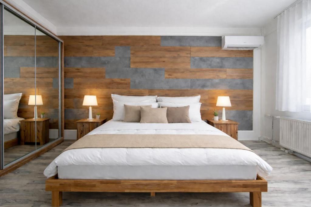 a bedroom with a large bed and two lamps at Comfort 18 Real Family Home in Miskolc