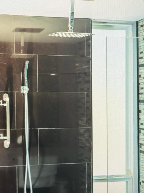 a bathroom with a shower with black tile at Spectacular views Atlantic Ocean in Basseterre
