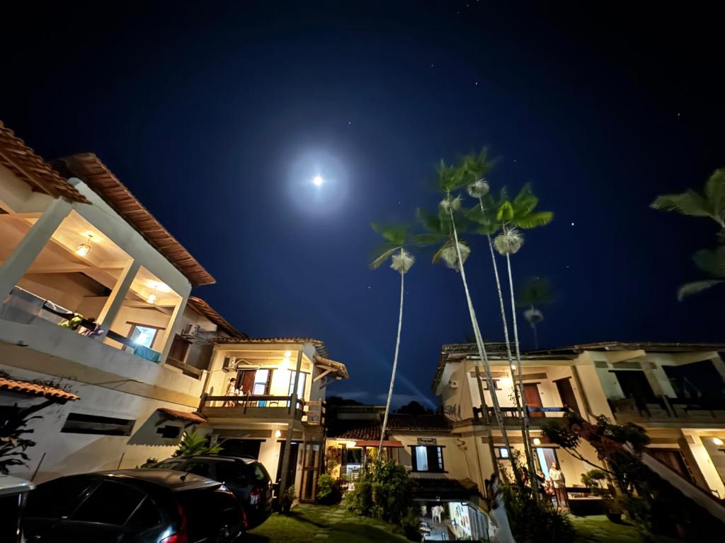 due palme davanti ad alcune case di notte di Pousada Vila Verde a Olivença