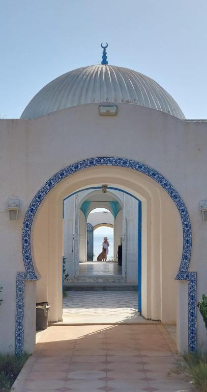 an archway leading into a building with a person in the background at Casa Madame Aïcha in Sousse