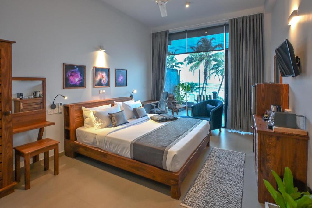 a bedroom with a bed and a living room at Mawakada Bay Residences in Hikkaduwa