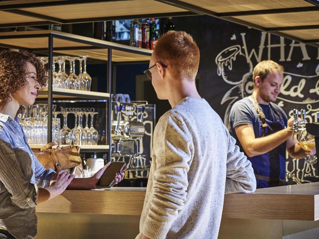 a group of people standing at a bar at ibis Bethune Centre Gare in Béthune
