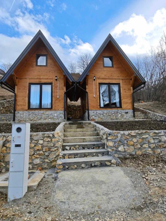 a home with a stone staircase leading up to it at Vikendica Neven 2 in Zaovine