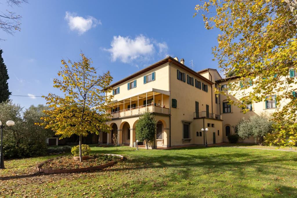 een groot wit gebouw met een boom in de tuin bij Villa La Stella in Florence