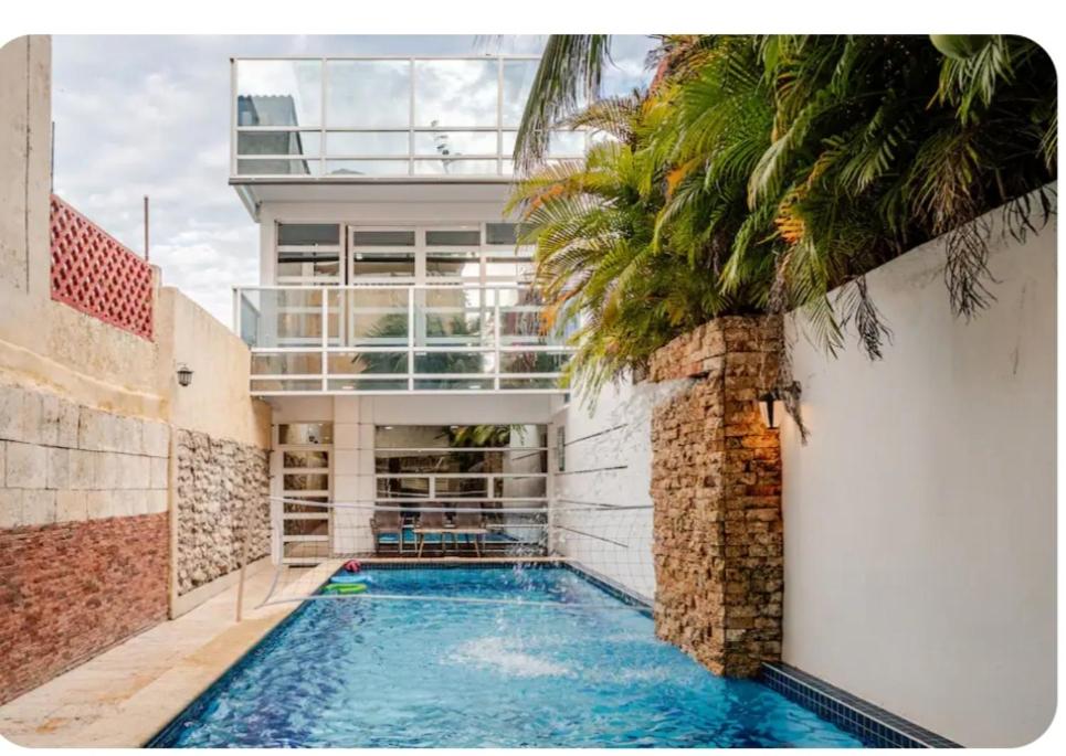 a house with a swimming pool in front of a building at Casa con Piscina Privada Playas del Mar in Cartagena de Indias