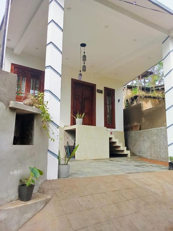 a house with a porch and stairs in front of it at Hurley vila in Weligama