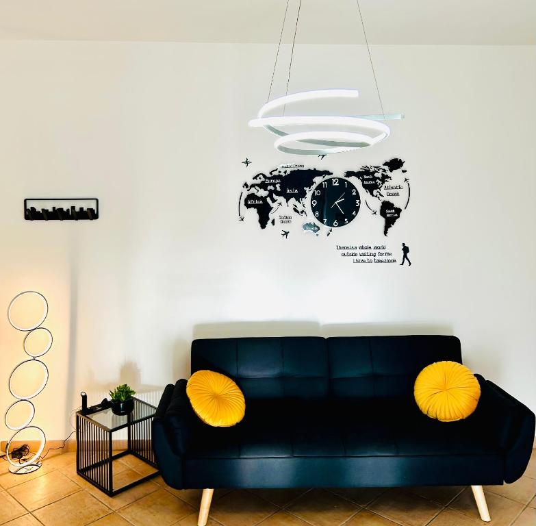 a black couch in a living room with a map of the world at Urban Chic Apartment in Valmontone