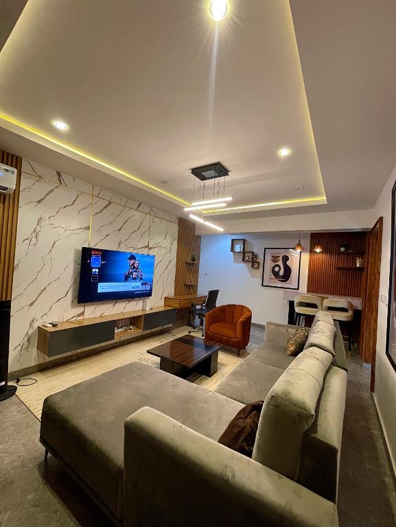 a living room with a couch and a flat screen tv at Exotic Two bedroom apartment in Abuja