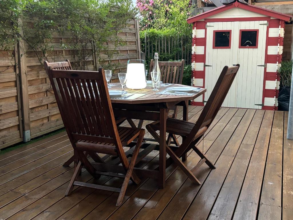 ein Tisch und Stühle auf einer Terrasse mit einem Hühnerstall in der Unterkunft 3 pièces avec terrasse arborée in Arcachon