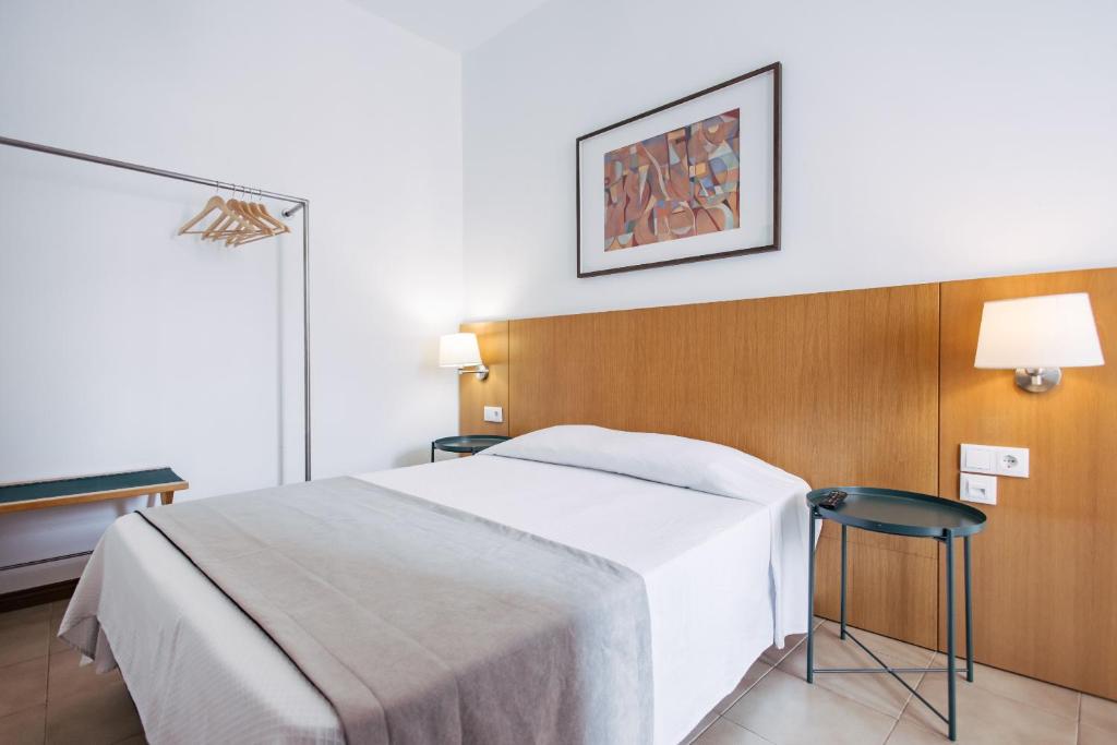 a bedroom with a white bed and two chairs at Murças74 - Studio Apartments in Funchal