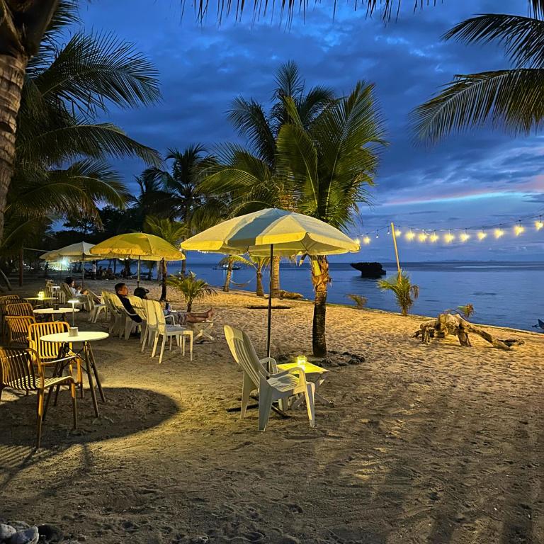 a beach with chairs and umbrellas on the beach at Gold View Beachfront Resort in Timbaon