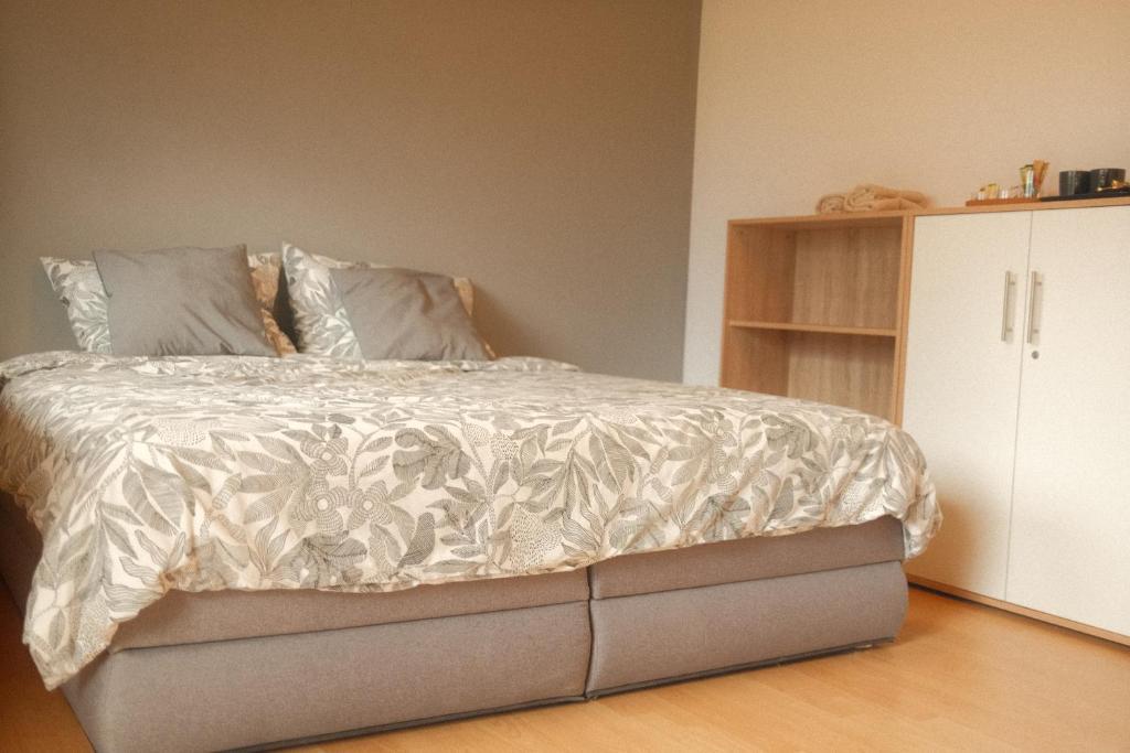 a bedroom with a bed with a white comforter at Pension Zum Waldrand in Sinsheim