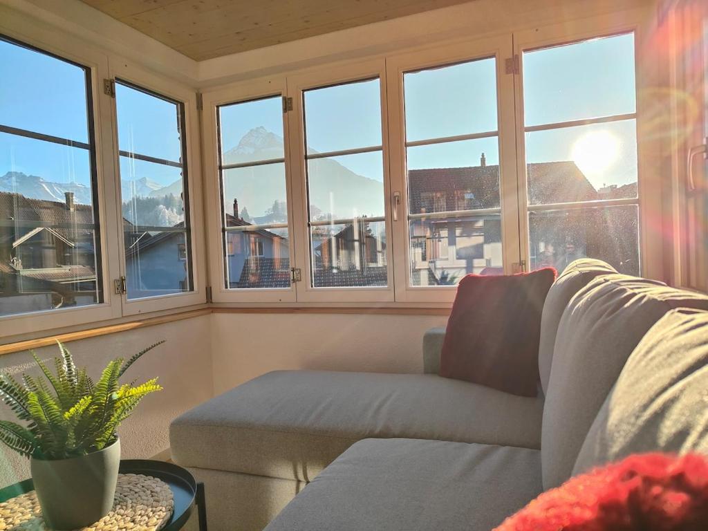 a living room with windows and a couch at Frutigen 20 nach Interlaken in Frutigen
