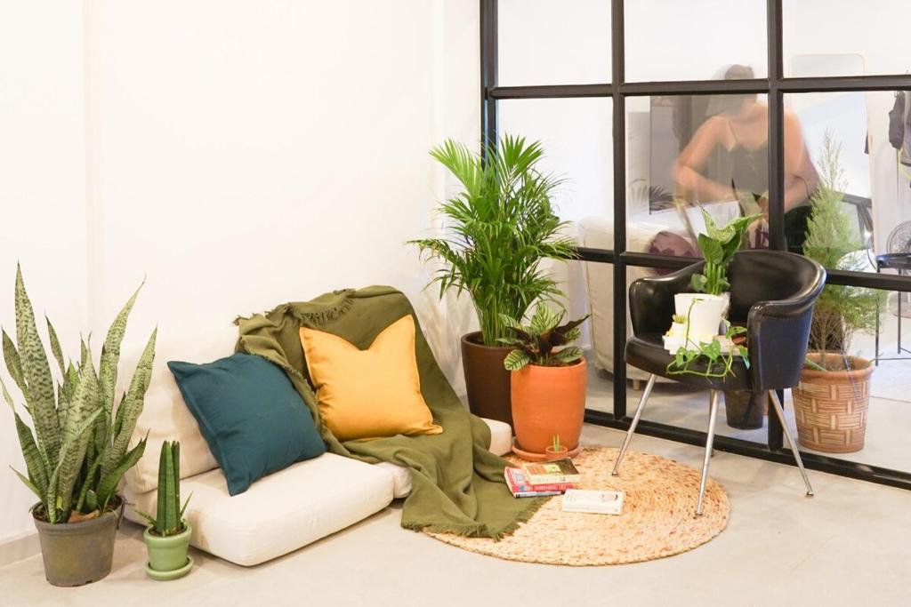 a living room filled with lots of plants and a couch at Tiny home Pana B Private residence 10mins beach in Bophut