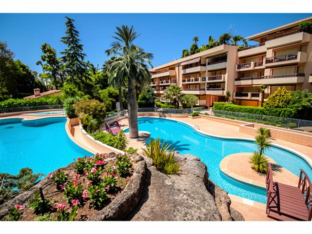 a large swimming pool in front of a building at Beautiful 36m2 studio apartment & 50m2 terrace in Cannes