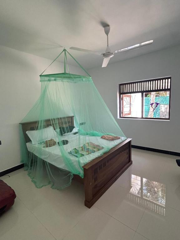 a bedroom with a bed covered in a net at White Umbrella - Homestay in Beruwala