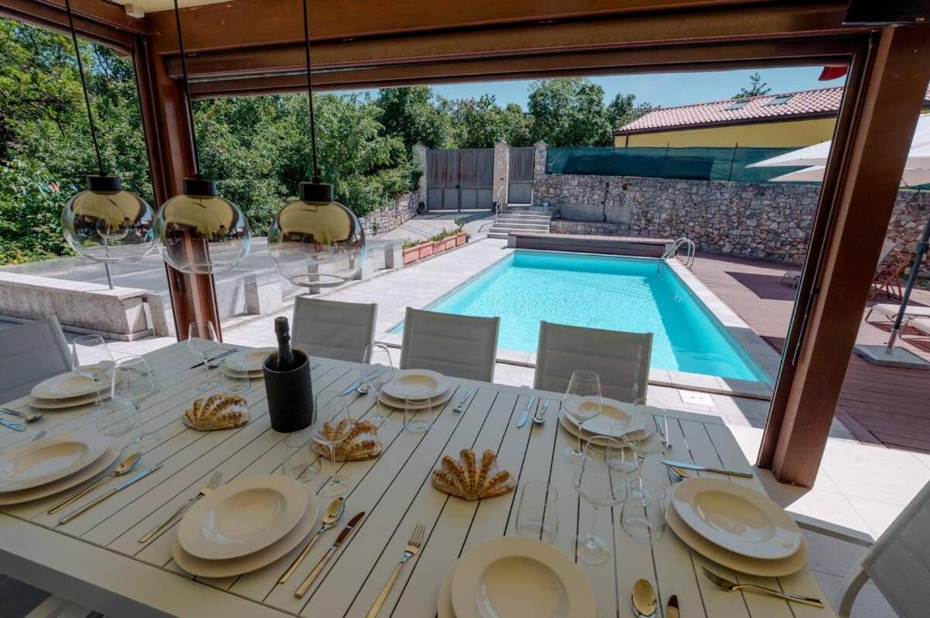 a table with plates of food on it next to a pool at Trieste - Villa Prosecco in Prosecco