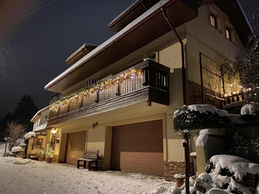 een huis met een garage in de sneeuw 's nachts bij Apartmán Donovaly Mišuty 586 in Donovaly