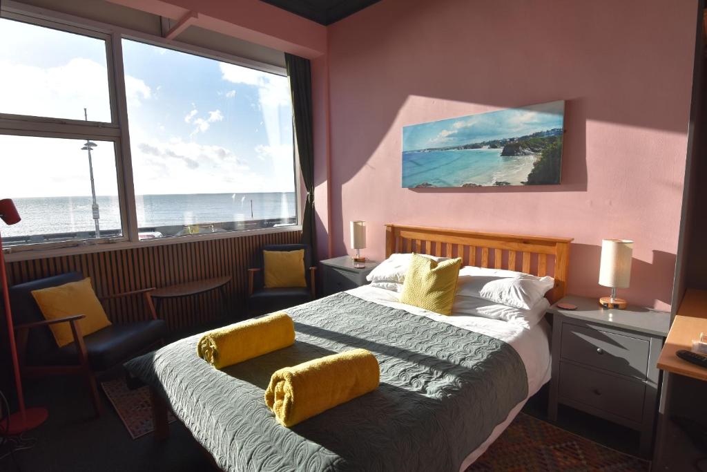 a bedroom with a bed with a view of the ocean at Westpoint Apartments in West Bay