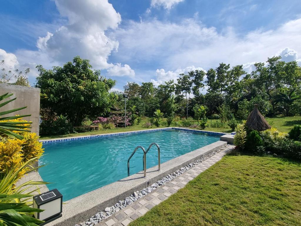 una piscina nel cortile di una casa di Miracle's Farm at Tarlac 