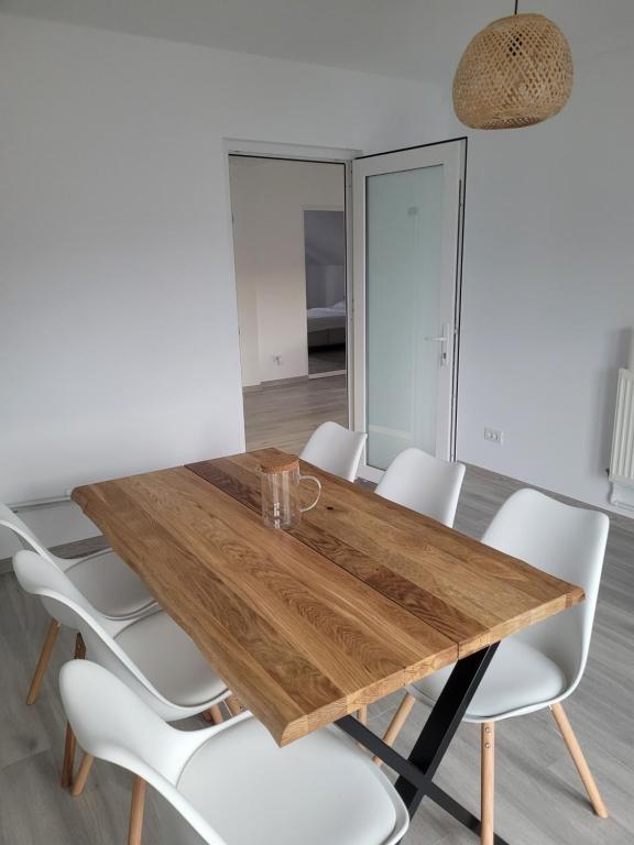 een eetkamer met een houten tafel en witte stoelen bij Casa Nițică in Vaslui