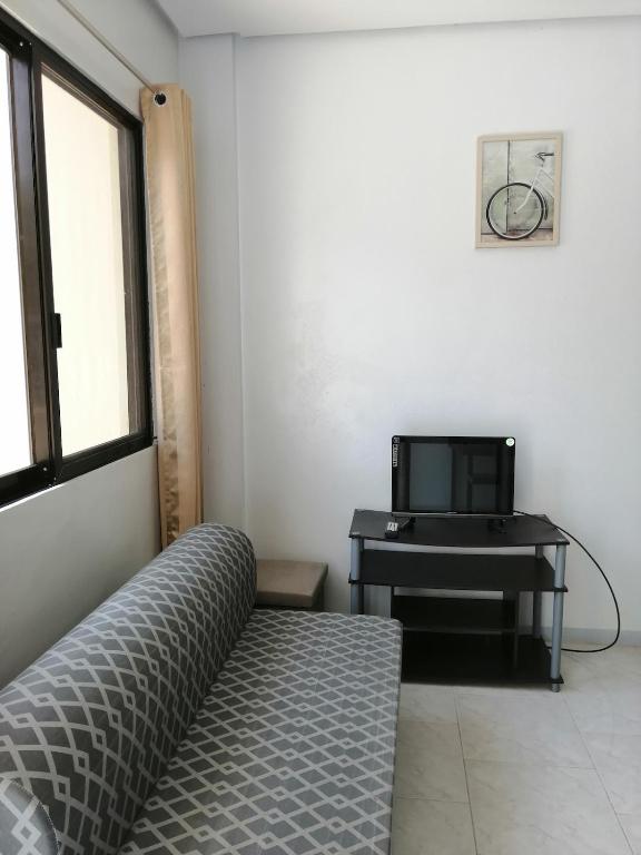 a living room with a couch and a desk at Silay Haven Near Airport by One Guest Place 3919B in Silay