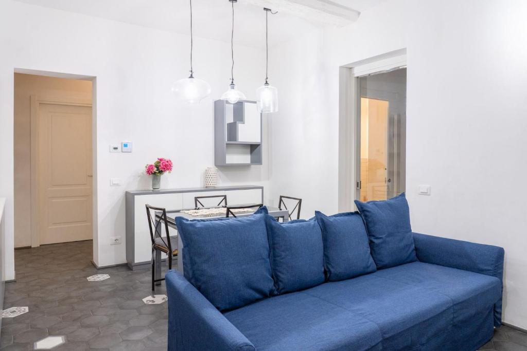 ein blaues Sofa im Wohnzimmer mit einem Tisch in der Unterkunft Emilia Suite Edition in Modena