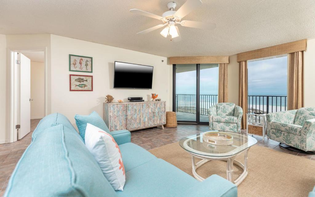 a living room with a blue couch and a tv at Phoenix East II 2033 in Orange Beach