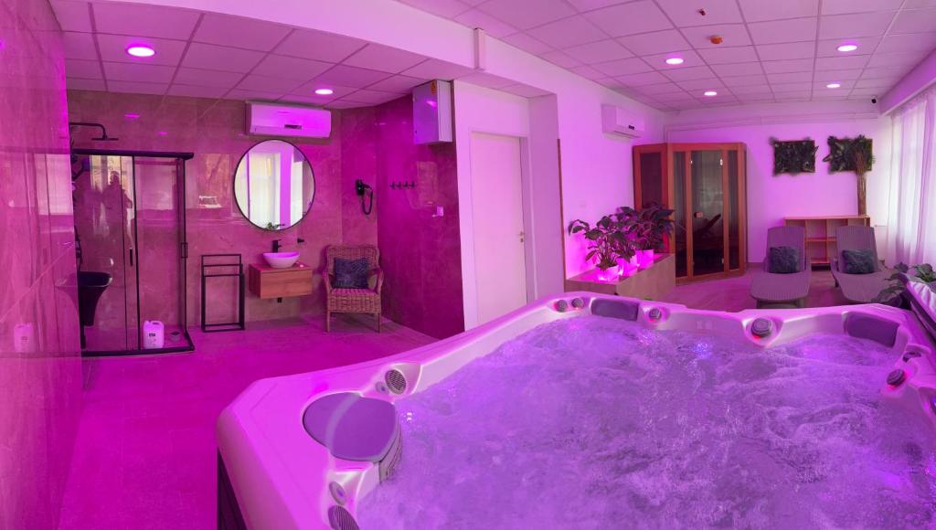 een paarse badkamer met een groot bad in een kamer bij Plaza Hotel Gyula in Gyula