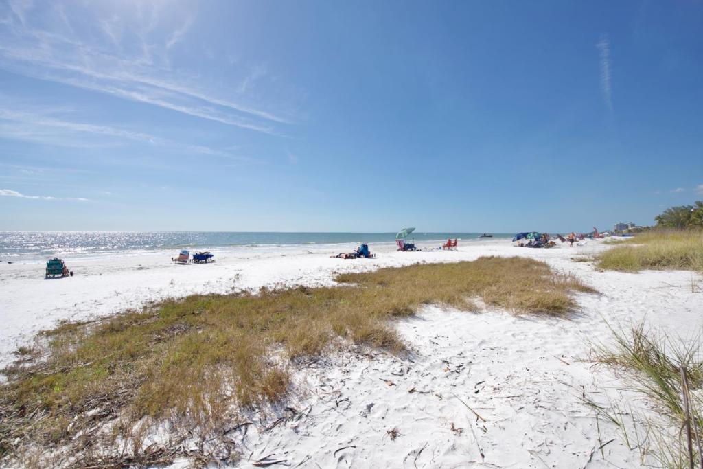 a group of people sitting on a sandy beach at Punta Rassa Pointe by Sun Palace Vacations in Fort Myers