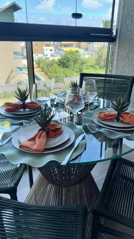 a glass table with plates and napkins on it at Beach Class Summer in Porto De Galinhas