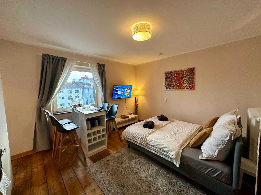 a bedroom with a bed and a desk and a window at Stilvolles 2-Zimmer-Apartment in Bremen in Bremen