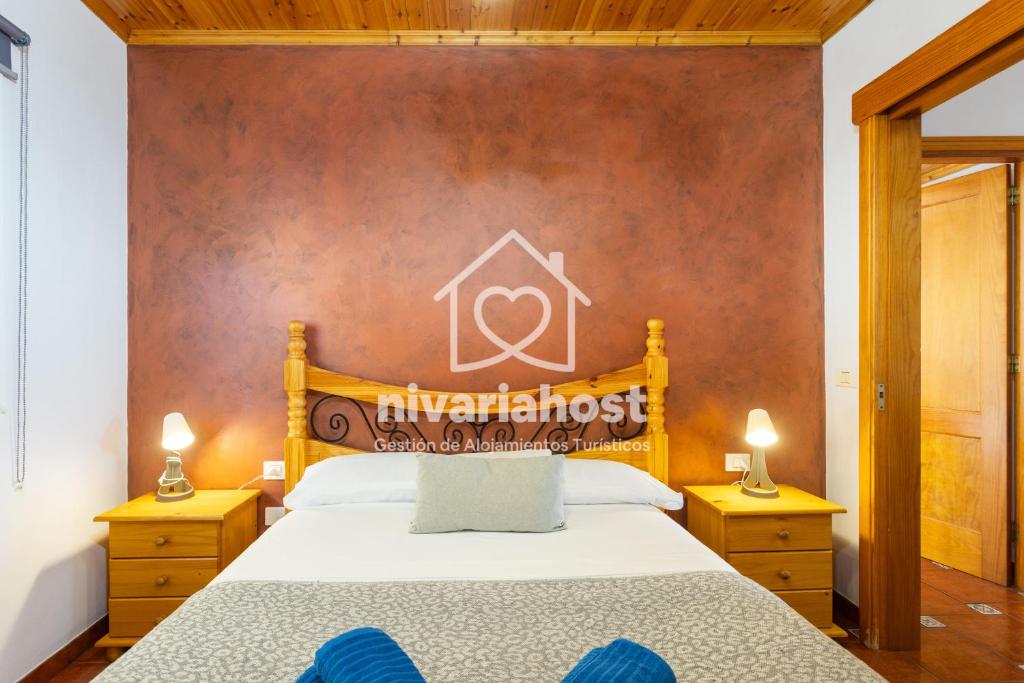 una camera da letto con un letto grande con testiera in legno di El Pescador El Pris, by Nivariahost a El Pris