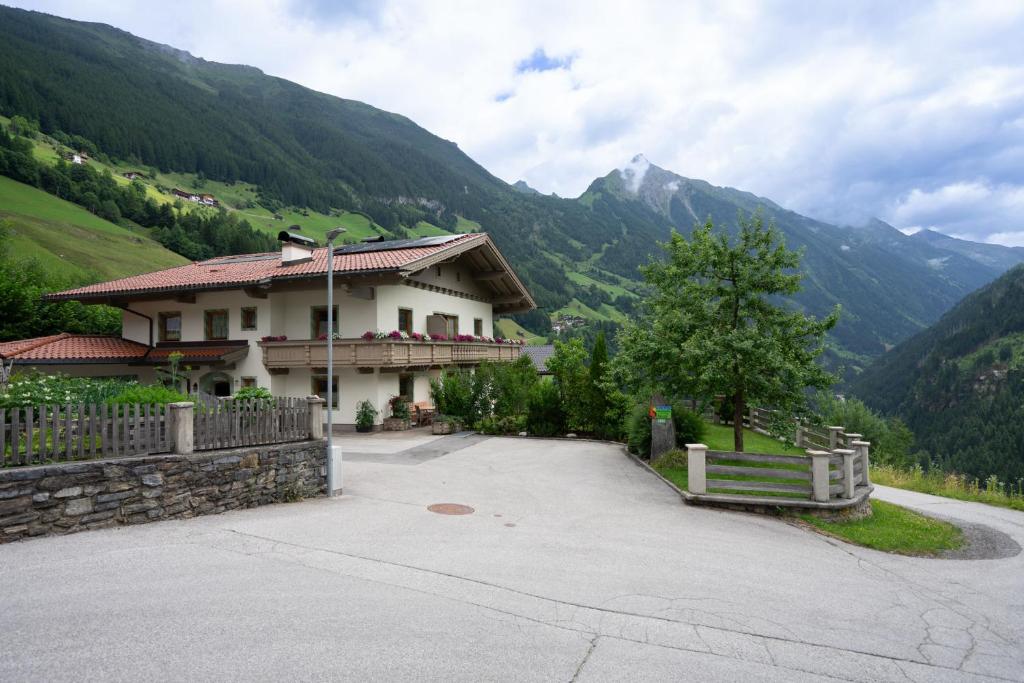 a house on a hill with mountains in the background at Panoramablick Ferienwohnung Schiestl in Brandberg