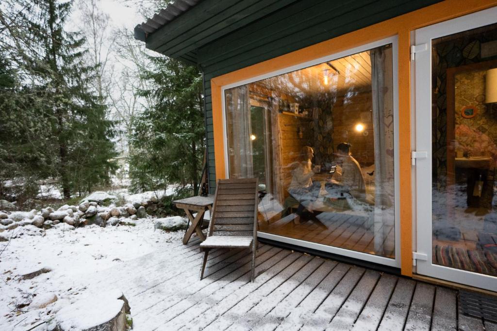 eine abgeschirmte Veranda mit einer Bank und einem Tisch in der Unterkunft Ennu’s hut in Loksa