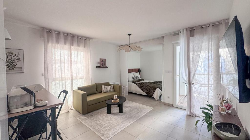 a living room with a couch and a room with a bed at Studio récent avec terrasse Clim Airbus Aéroport in Colomiers