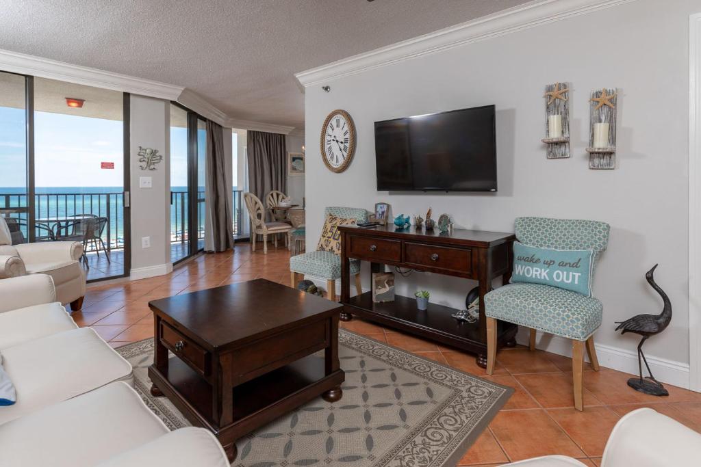 a living room with a couch and a table and a tv at Phoenix East II 2072 in Orange Beach